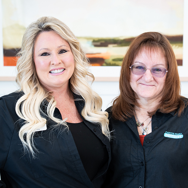 Two team members at Canyon Family Dental smiling in the office.